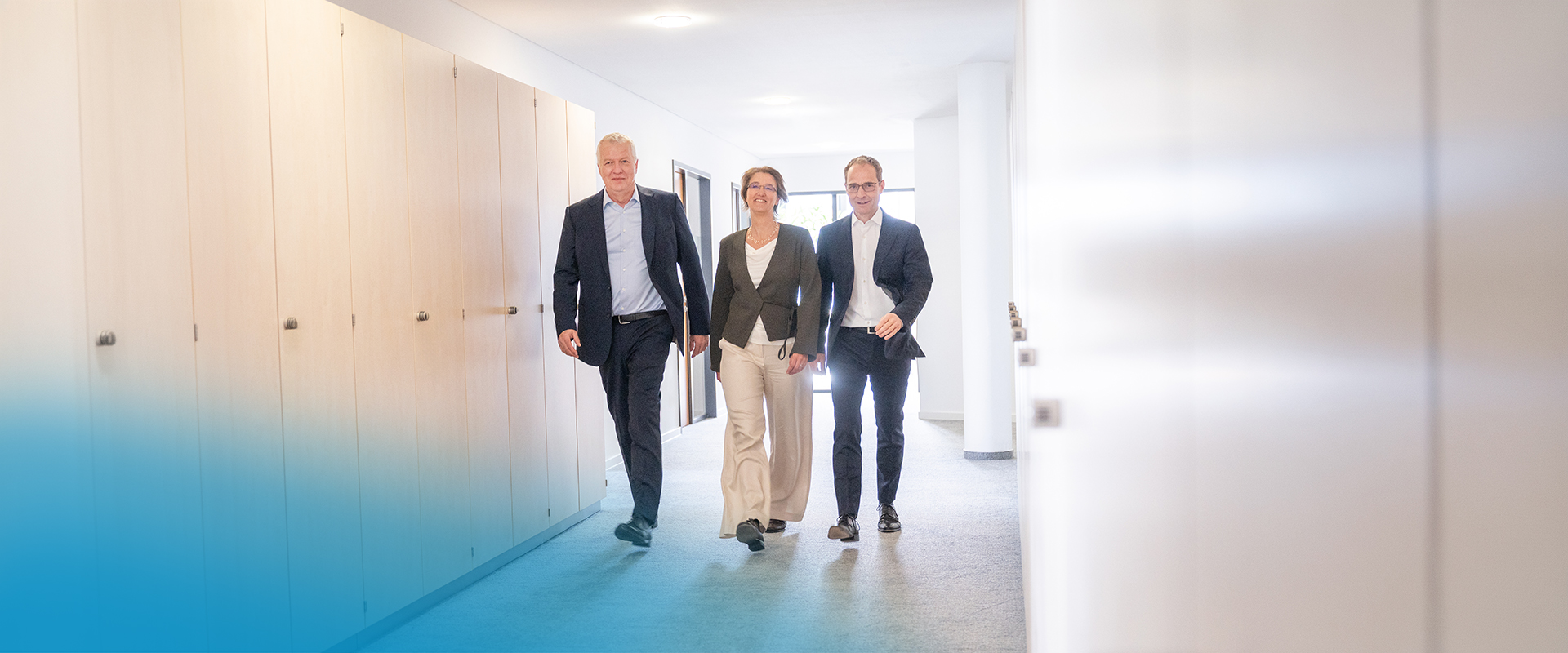 Drei Personen gehen im dynamischen Schritt auf die Kamera zu